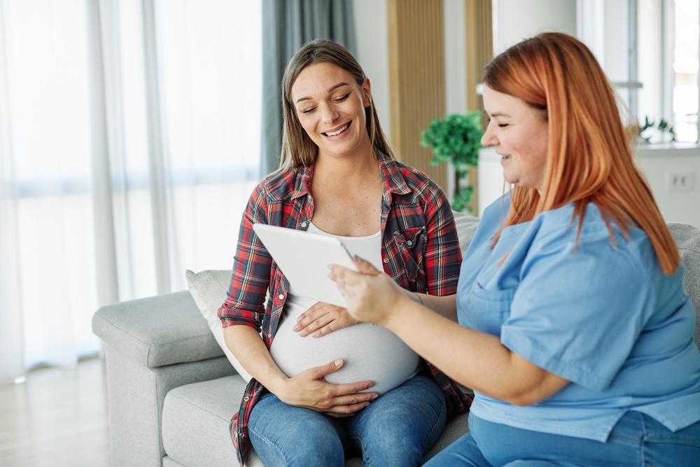 Wir helfen auch bei Schwangerschaft Mitarbeitende spricht mit einer Schwangeren
